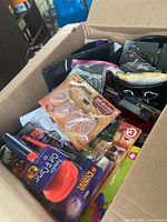 Open box showing variety of Halloween items including face paints, packaged accessories and bucket