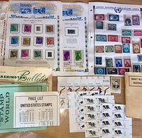 Various album pages, mint plate blocks, UN sheet, Israel page and pamphlets spread on table