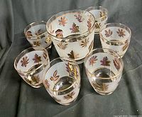 Overhead angled view showing ice bucket and six tumblers displaying interior and exterior finish