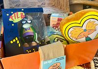 Box interior showing Filbert figurine, Hey Arnold heart pillow, socks, glimpse of blanket