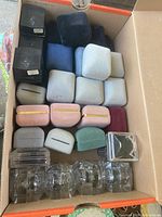 Assorted velvet, acrylic and cardboard jewelry boxes inside shoebox