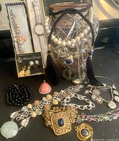 Overall view of lot with jar of jewelry, boxed sets, loose pieces displayed