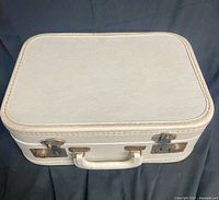 Closed view of cream hard-sided overnight case