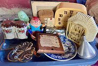 Full lot overview on blue tray showing clock, dishes, glass, plaque, funnel, napkin holder, memo clip, burlap sack