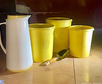 set of three yellow canisters, white/yellow pitcher, metal scoop