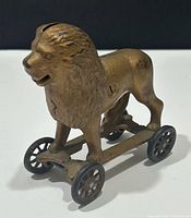 Front three-quarter view showing lion figure, wheels, coin slot