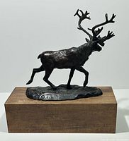 Front view of bronze caribou sculpture on wood base