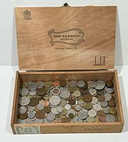 Open cigar box filled with assorted coins