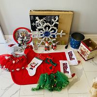 All items laid out, showing stockings, tins, gnomes, tinsel tree, garland, charger plate, glass, LED snowflake box