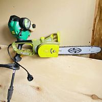 Overall view of Sun Joe chain saw with part of gas trimmer visible