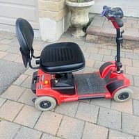 Full side view of red Pride Go-Go 4-wheel mobility scooter with seat and tiller