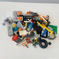 Pile of assorted LEGO pieces including remote, tire, bricks