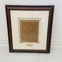 Full view of framed document under glass