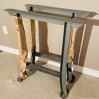 Pair of steel legs against wall, brown paper protecting uprights