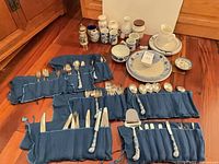 Overview of Blue Danube flatware in rolls, porcelain pieces, pepper grinder