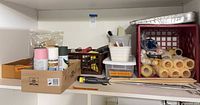 Shelf with boxes and crates holding spray cans, roller sleeves, trays, tools