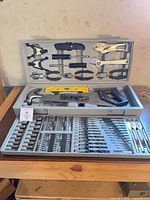 Open tool kit showing full assortment including hammer, saw, level, clamps, pliers and drill bits