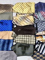 Overview of 15 of the ties laid out flat showing patterns and colours