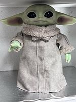 Front view of Grogu plush standing on shelf