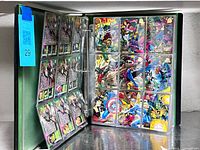 Open binder showing multiple nine-pocket pages filled with Marvel trading cards