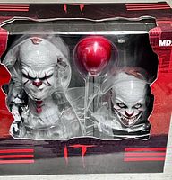 Front of sealed box showing Pennywise figure, alternate head and balloon