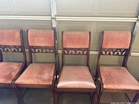 Front view of four of the chairs showing upholstery and cut-out backs