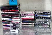 Stack of CDs, stack of cassettes and microcassettes on tabletop