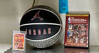 Basketball, trading card, and NBA DVD displayed together