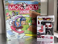 Monopoly Junior and Funko Pop figure visible; unrelated items also show shrink-wrapped game boxes for scale context