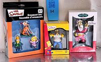 Front view of all three boxed Simpsons ornaments