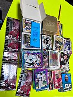 overview of loose cards, five sealed Topps packs, open card box