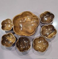 Top view of large bowl and six small bowls showing lotus shapes and finish
