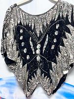 Front view of black silk blouse with silver sequin butterfly design