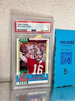 Front view of PSA-slabbed 1990 Topps Joe Montana card showing grade and cert label