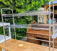 Full view of chrome two-tier rack on table outdoors