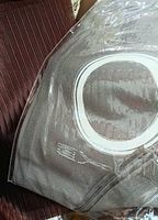 Brown striped placemat next to grey placemat sealed in plastic