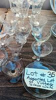 Assorted etched glasses on table including goblets and coupes