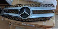Front grille showing chrome bars, black mesh, Mercedes emblem