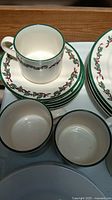 Cups, saucers and dinner plates showing holly border