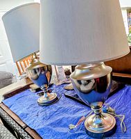 Two matching brushed silver table lamps with shades