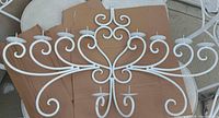 front view of white wrought iron wall candle holder showing all 10 candle plates