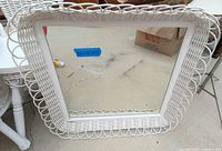 Front view of square white wicker framed mirror