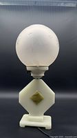 Full view of lamp showing alabaster base and frosted globe shade