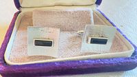 Pair of cufflinks displayed in velvet-lined box