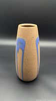 Front view of brown textured vase with blue drip glaze