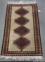 Full view of rectangular brown and beige wool rug with white fringe
