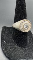 Front view of sterling silver ring showing central round cubic zirconia and surrounding baguette stones