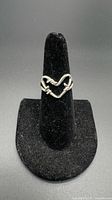 Full view of twisted heart sterling silver ring on display stand