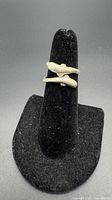 Front view of sterling silver dolphin ring on stand