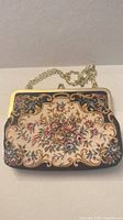 Front view of floral needlepoint tapestry purse showing overall design, frame and chain